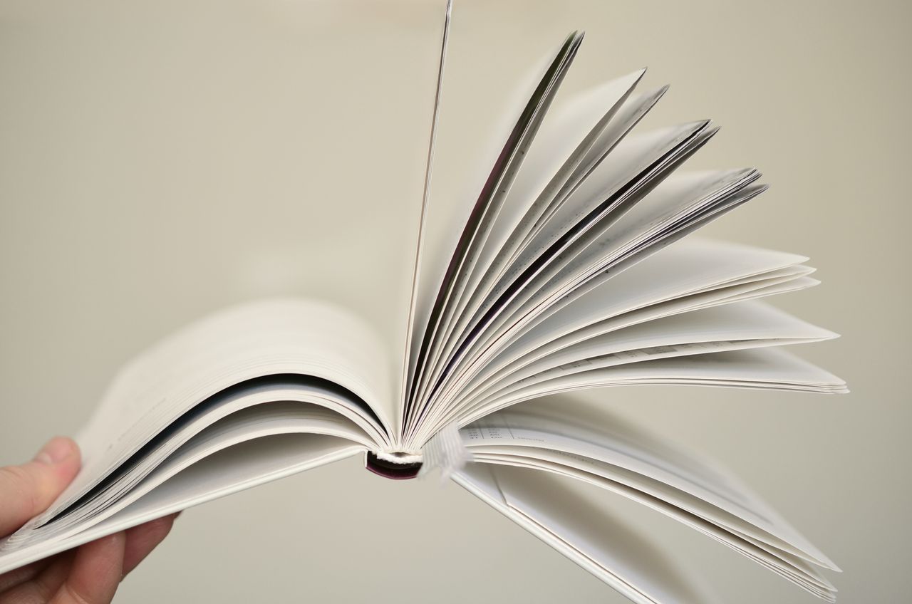 Home Close-up of an open book with pages flying, symbolizing knowledge and learning.